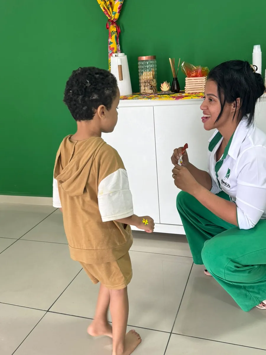 Profissional da Atend Já conversando com criança na clínica